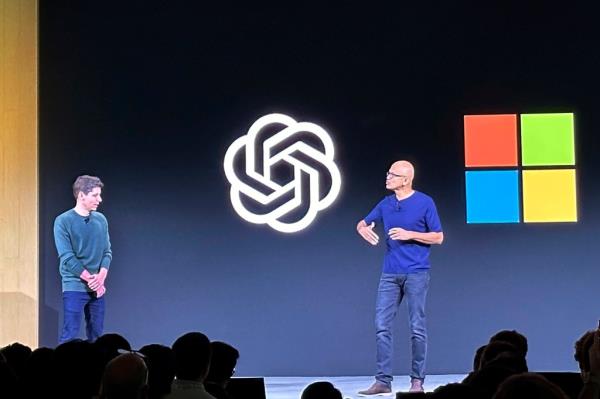 Satya Nadella and Sam Altman on stage with a large screen in the background.