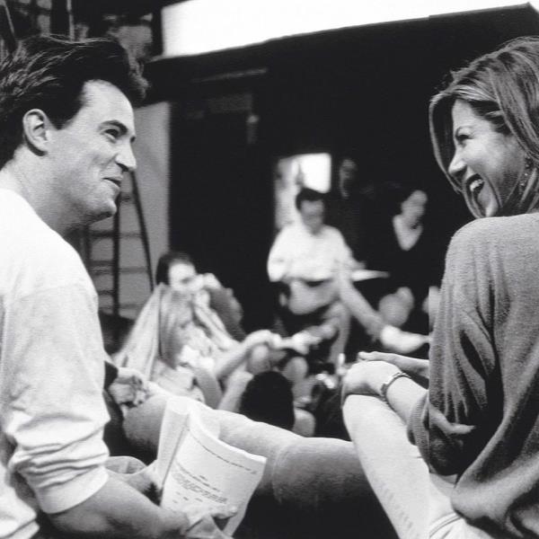 Jennifer Aniston and Matthew Perry smiling at each other. 