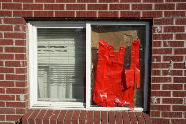 A broken window, secured with red tape, sits on display at an apartment complex in Aurora Colorado, on Oct. 10, 2024.