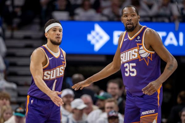 Phoenix Suns guard Devin Booker shaking hands with forward Kevin Durant during a 2024 NBA playoffs game against the Minnesota Timberwolves