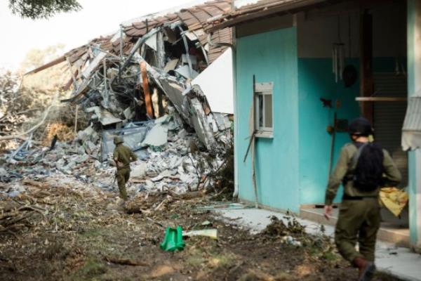 BE'ERI, ISRAEL - OCTOBER 14: 4: Israeli soldiers walk near houses that were destroyed in a battle between Israeli soldiers and Palestinian militants on Saturday's Hamas attack on the kibbutz on October 14, 2023 in Be'eri, Israel. Israel has sealed off Gaza and launched sustained retaliatory air strikes, which have killed at least 1,400 people with more than 400,000 displaced, after a large-scale attack by Hamas. On October 7, the Palestinian militant group Hamas launched a surprise attack on Israel from Gaza by land, sea, and air, killing over 1,300 people and wounding around 2,800. Israeli soldiers and civilians have also been taken hostage by Hamas and moved into Gaza. The attack prom<em></em>pted a declaration of war by Israeli Prime Minister Benjamin Netanyahu and the announcement of an emergency wartime government. (Photo by Amir Levy/Getty Images)