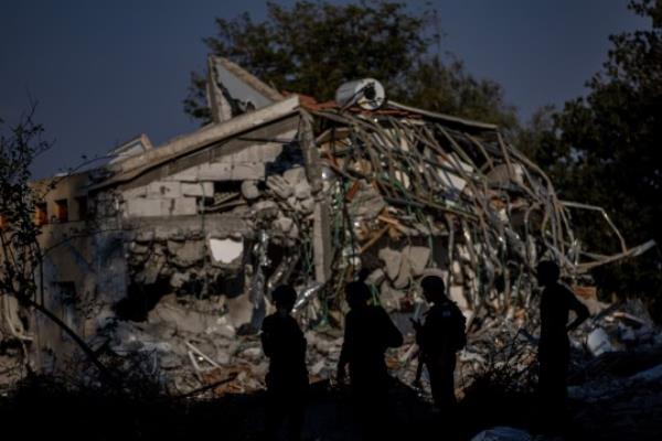 epa10919099 Israeli soldiers stand next to a damaged house in the kibbutz of Be'eri, Israel, 14 October 2023. According to Israeli officials, the bodies of 108 Israeli people were found in the Be'eri kibbutz, near the Gaza border, following the Hamas attack on 07 October. More than 1,300 Israelis have been killed and over 3,200 others injured, according to the IDF, after the Islamist movement Hamas launched an attack against Israel from the Gaza Strip on 07 October. More than 2,000 Palestinians have been killed and over 8,700 others injured in Gaza since Israel launched retaliatory air strikes, the Palestinian health ministry said. EPA/MARTIN DIVISEK