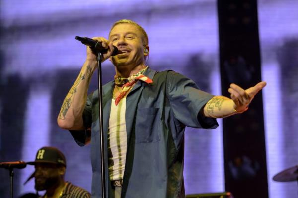 Macklemore performing o<em></em>nstage at the ibis RockCorps France 2024 event in Accor Arena, Paris, holding a microphone