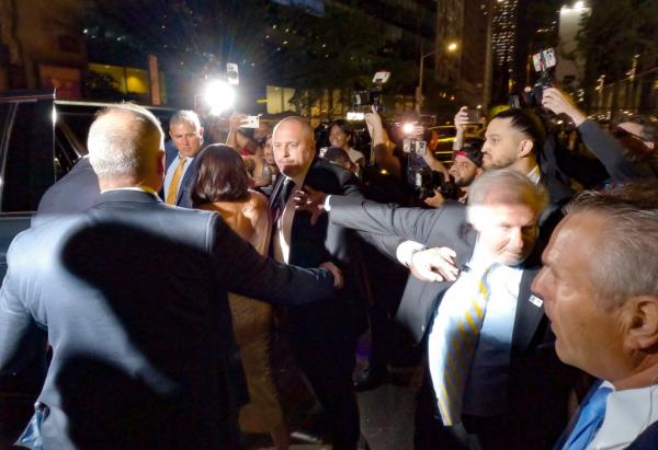 Security escorts Prince Harry, Duke of Sussex and Meghan Markle, Duchess of Sussex through a group of photographers outside The Ziegfeld Theatre on May 16 in New York City. 