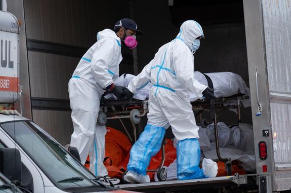 Workers move bodies to a refrigerated truck from the Andrew T. Cleckley Funeral Home in the Brooklyn borough of New York, Wednesday, April 29, 2020.