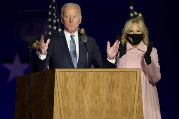 Democratic presidential nominee Joe Biden speaks at a drive-in election night event as Dr. Jill Biden looks on at the Chase Center in the early morning hours of November 04, 2020 in Wilmington, Delaware.