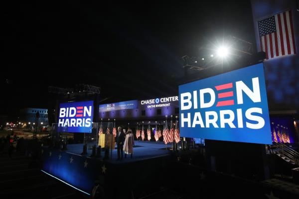 Democratic presidential nominee Joe Biden speaks at a drive-in election night event as Dr. Jill Biden looks on at the Chase Center in the early morning hours of November 04, 2020 in Wilmington, Delaware.