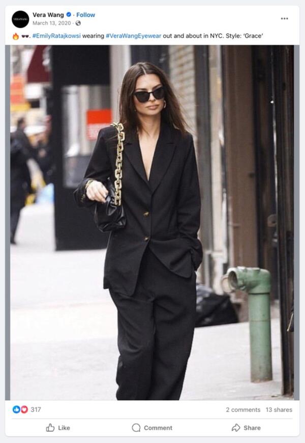 A photo of Emily Ratajkowski walking down the street clad in an all black ensemble with handbag.