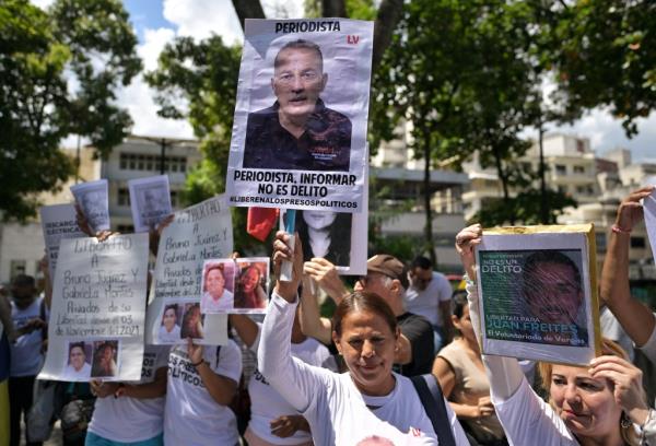 Demo<em></em>nstrators show posters of people arrested for protesting against the government of President Nicolas Maduro, during a protest at Brazilian embassy in Caracas on September 11, 2024.