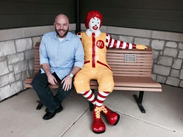 Mike Haracz, a former McDonald's executive chef, sitting with a Ro<em></em>nald McDo<em></em>nald statue on a bench. 