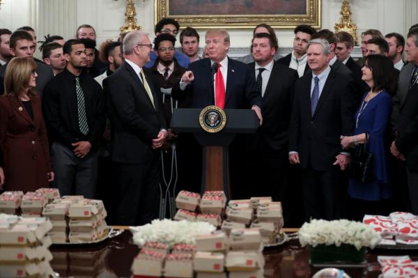 Trump speaking in front of McDonald's hamburgers.